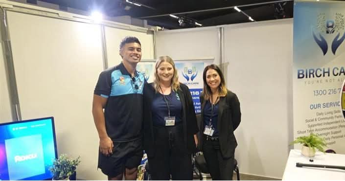 Birch Care team members at their stand at a disability expo, beside a Birch Care banner