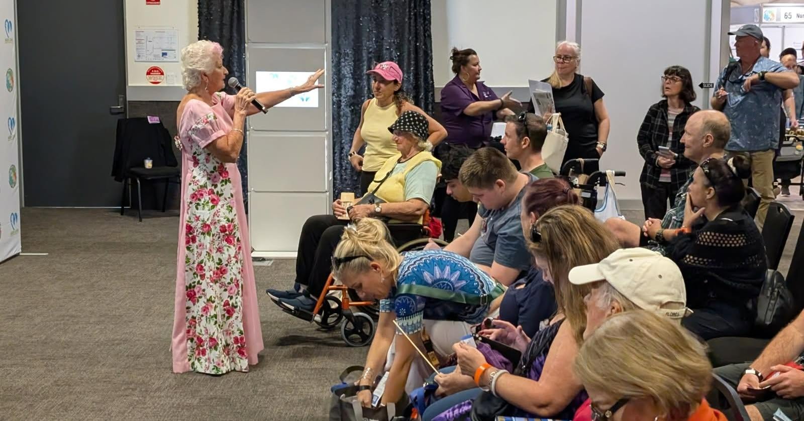 Participants and carers seated at a disability information session, listening to a speaker
